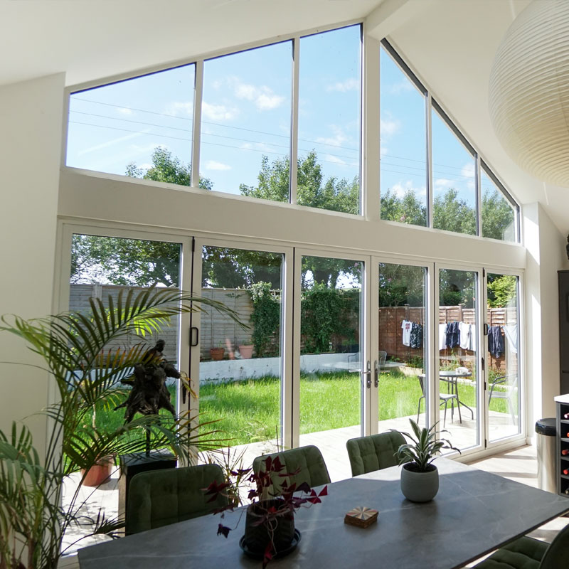 Aluminium bi-fold & sliding doors opening out onto a garden 