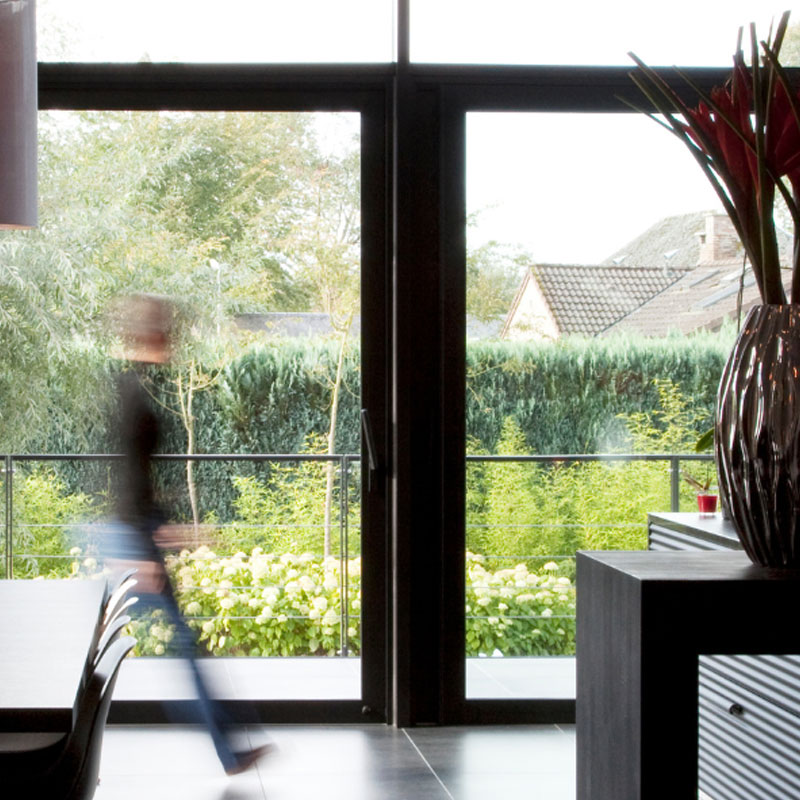 Dark colured kitchen doors leading out to a garden
