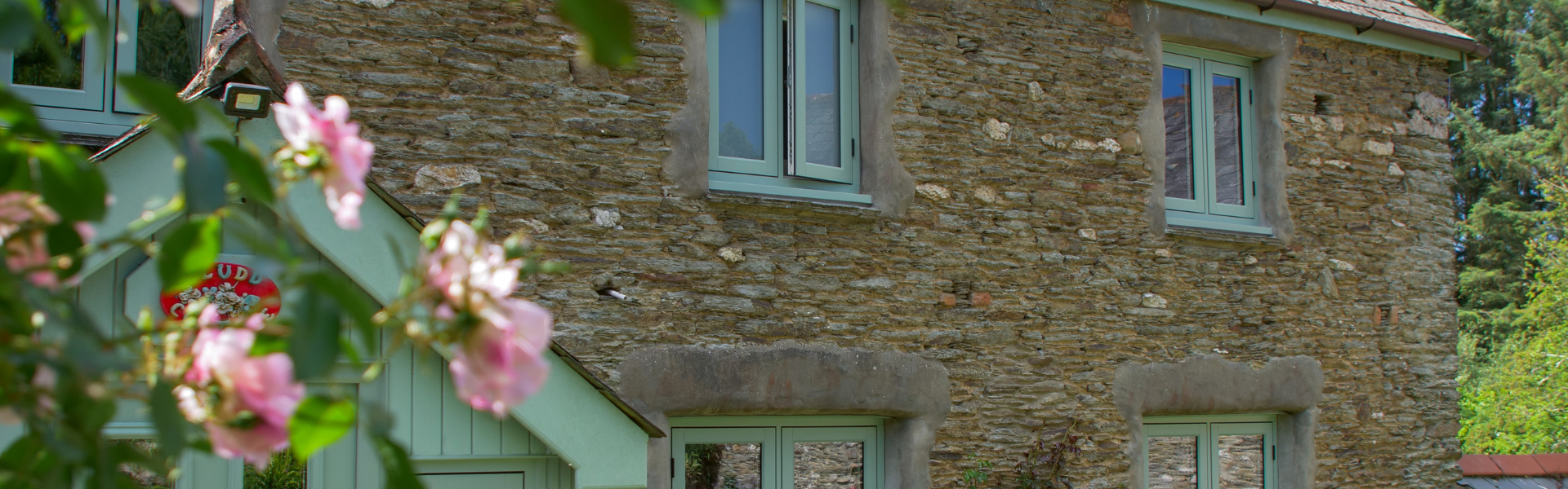Residence Windows on stone cottage in green with flowers