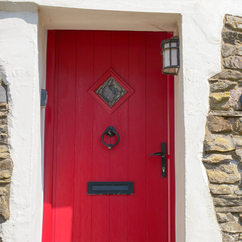 Red coloured Solidor Door to a stone cottage in North Devon