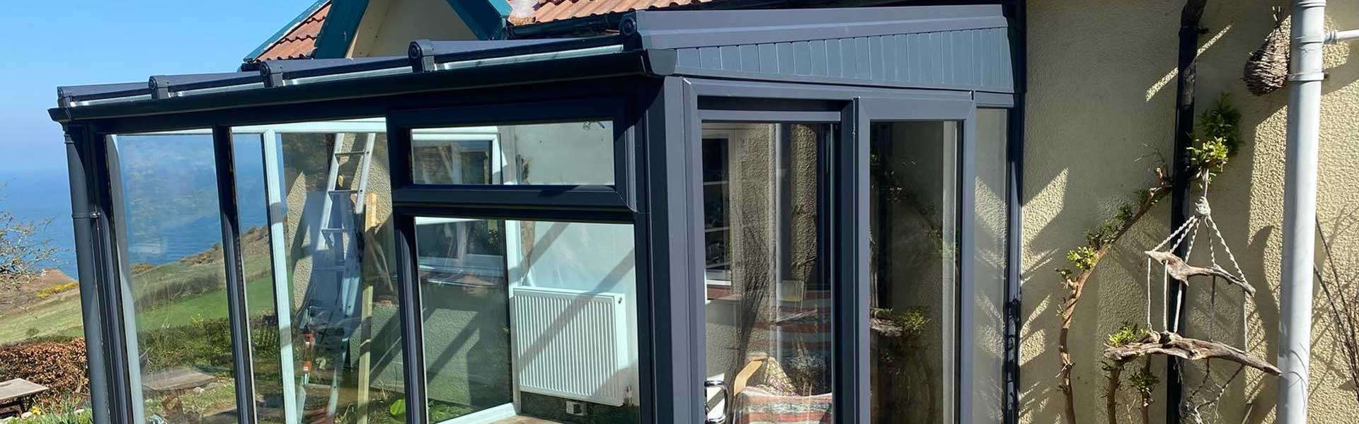 A fitted dark grey upvc conservatory with sea views in North Devon