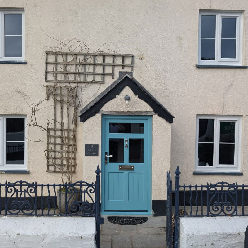 Blue coloured wooden door fitted to a Devonshire cottage