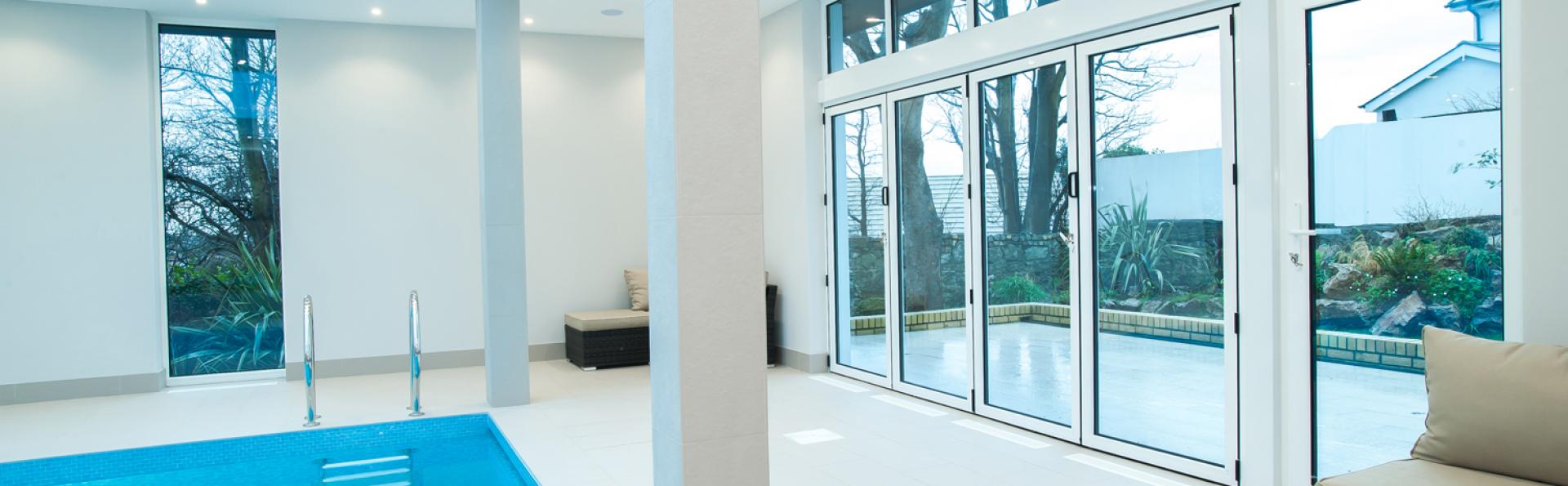 Aluminium bi fold doors by a swimming pool