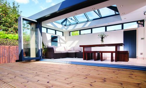 Skyroom opening out onto decking area connects the house with the garden