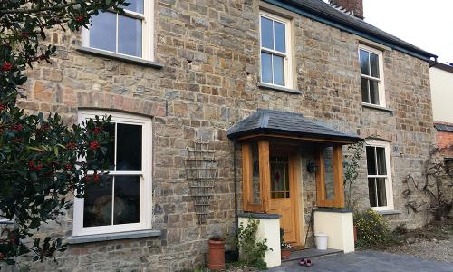 replaced sash windows in cream in wood effect upvc