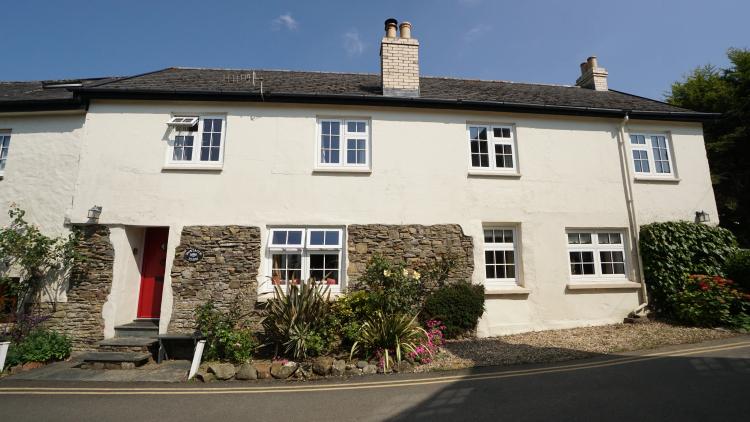 Cottage with white coloured windows and red door