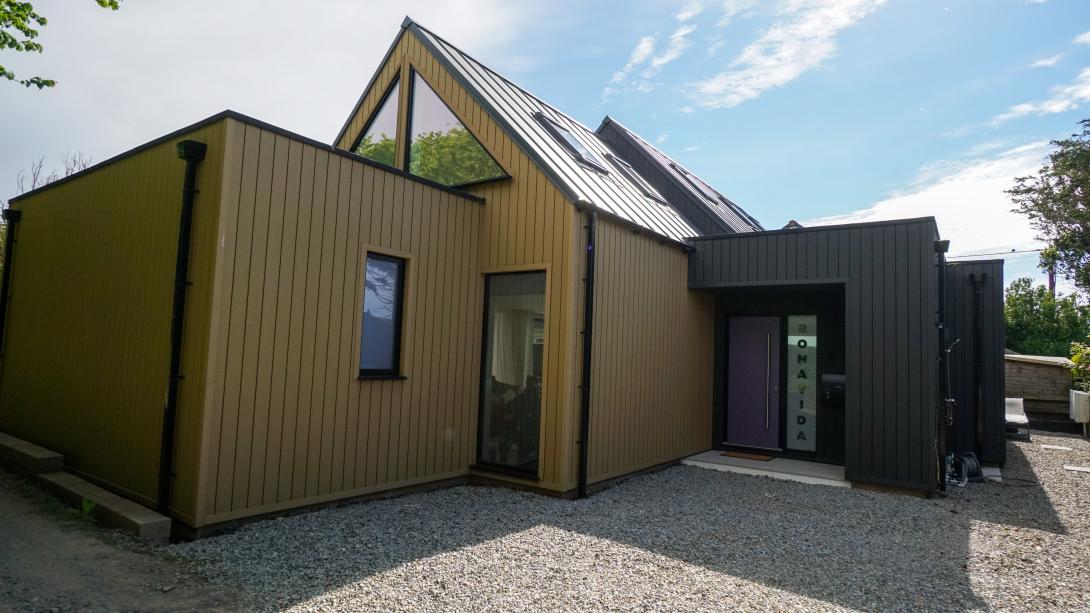 Brown and grey cladded housed with aluminium windows and a designer door