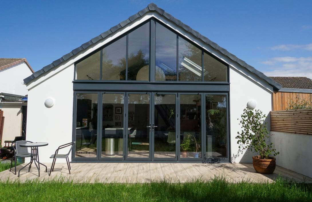 Closed grey coloured patio doors looking into kitchen area of a house