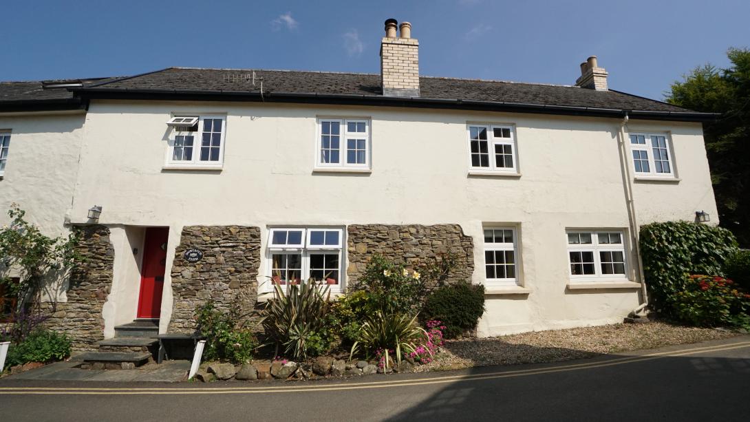 Cottage with white coloured windows and red door