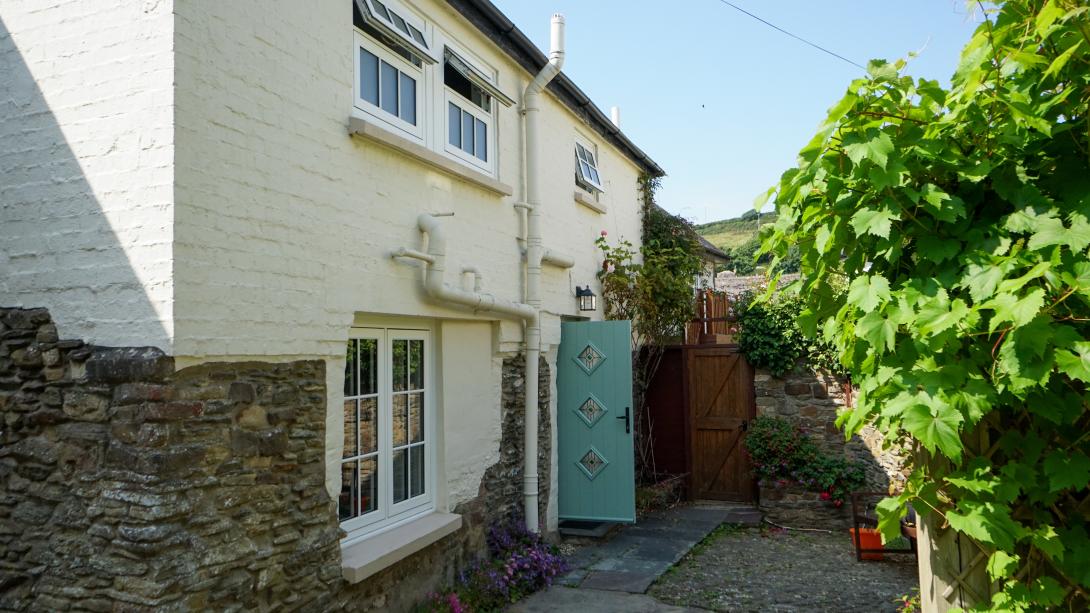 Cottage with white coloured windows and green door
