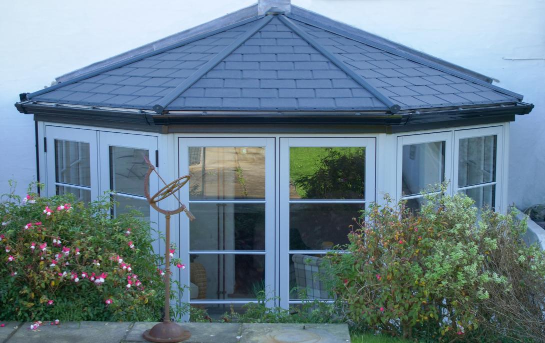 Conservatory featuring Residence 7 side frames and elegant French doors and a solid Ultraroof warm core roof featuring slate-effect tiles