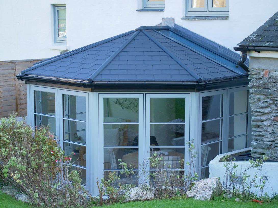 Conservatory featuring Residence 7 side frames and elegant French doors and a solid Ultraroof warm core roof featuring slate-effect tiles